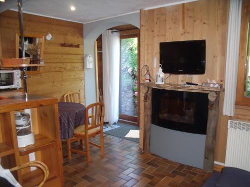 een woonkamer met een televisie en een eetkamer bij studio a proximite des pistes in Saint-Chaffrey