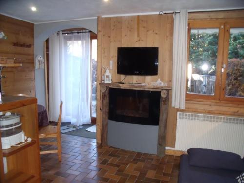 een woonkamer met een flatscreen-tv aan de muur bij studio a proximite des pistes in Saint-Chaffrey