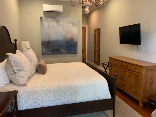 a bedroom with a bed and a flat screen tv at Terrell House Bed and Breakfast in New Orleans