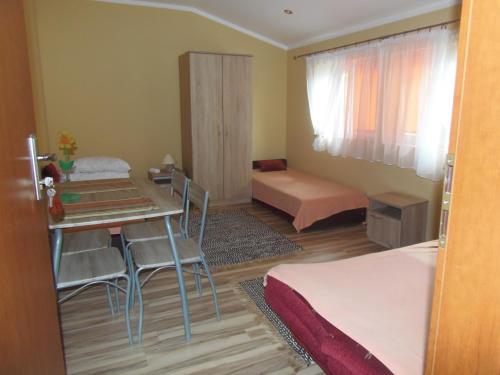 Majowy Domek في Posada Górna: غرفة صغيرة مع طاولة وكراسي وسرير