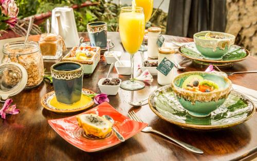 a wooden table topped with plates of food and drinks at La Colina Hotel Cottage in Bogotá