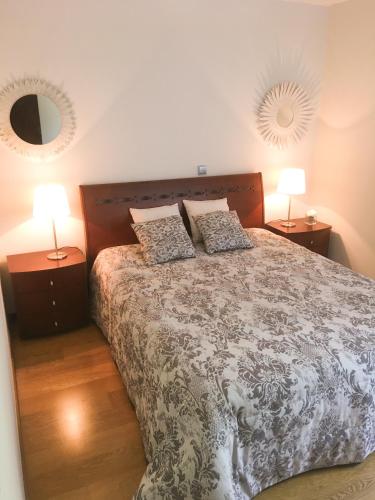 a bedroom with a bed with two lamps and a mirror at The River's Whisper Apartment in Geres