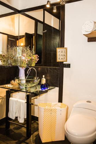 a bathroom with a glass table and a toilet at La Colina Hotel Cottage in Bogotá