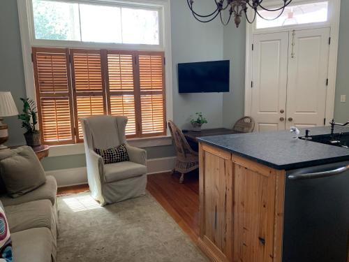 a kitchen with a counter and two chairs and windows at Terrell House Bed and Breakfast in New Orleans