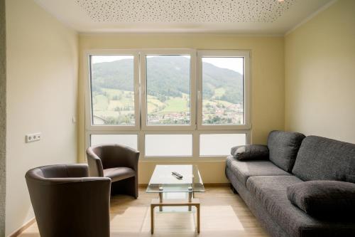 a living room with a couch and chairs and a large window at Mühlbacherhof in Rennweg