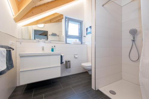 a white bathroom with a shower and a toilet at Apartmenthaus Horster in Bensheim