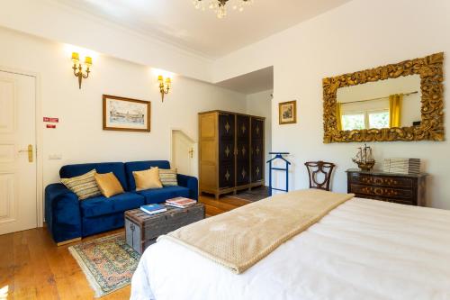 a bedroom with a bed and a blue couch at Geronimo Guest House Belém in Lisbon