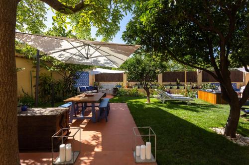 a patio with a table and an umbrella in a yard at Geronimo Guest House Belém in Lisbon