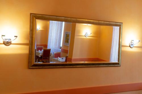 a mirror on the wall of a room with a dining room at Hotel Europa in Görlitz