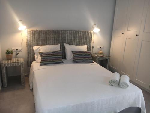 a bedroom with a large white bed with pillows at Bakagiannis Apartments in Parga