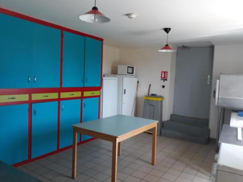 a kitchen with blue cabinets and a table at Maison de la Monne in Olloix