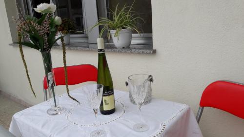 una mesa con una botella de vino y dos copas en Albergue Agarimo, en Caldas de Reis