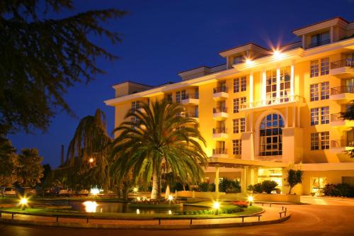 a large building with a palm tree in front of it at Hotel Dos Templarios in Tomar