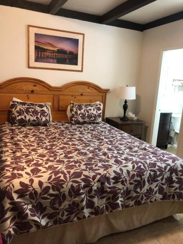 Schlafzimmer mit einem Bett mit einer schwarzen und weißen Bettdecke in der Unterkunft Ala Mar by the Sea in Santa Barbara