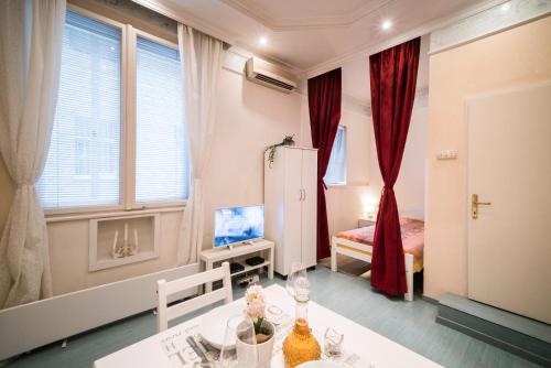 a room with a dining table and a bedroom at White Pearl Apartment in Belgrade
