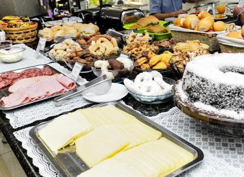 un buffet con molti tipi diversi di cibo su un tavolo di Vivendas Hotel a Erechim