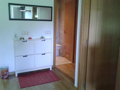 a bathroom with a white cabinet and a mirror at TORRE de la FUENTE AprtoVistas Piscina Parking in Oviedo
