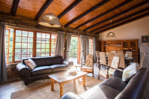Una sala de estar con sofás y una mesa. en Rivendell Trout Estate, en Lydenburg