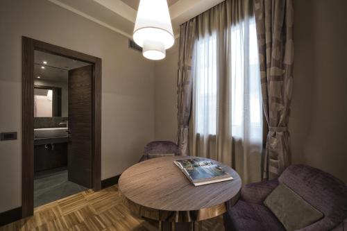 a room with a table and two chairs and a mirror at Solo Experience Hotel in Florence