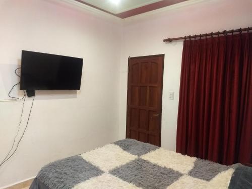 a bedroom with a bed and a flat screen tv at Ksa en la Linda in Salta