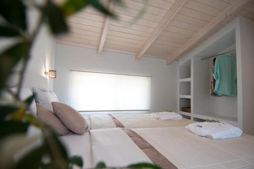 a bedroom with a bed with two pillows on it at Alba Al Mare Villette in Laganas