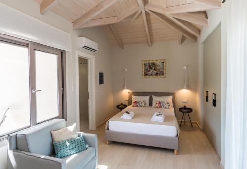 a bedroom with a bed and a chair in it at Alba Al Mare Villette in Laganas