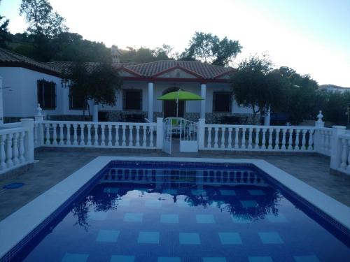 a house with a white fence and a swimming pool at LOS TRES PICOS in Prado del Rey