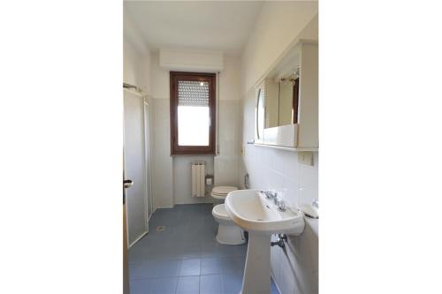 Baño blanco con lavabo y aseo en Tommaso 3 Sopra, en Tuoro sul Trasimeno