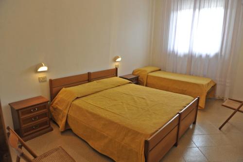 1 dormitorio con 2 camas y ventana en Tommaso 5, en Tuoro sul Trasimeno