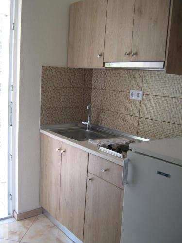 a kitchen with a sink and a refrigerator at Studios Venetia in Astris