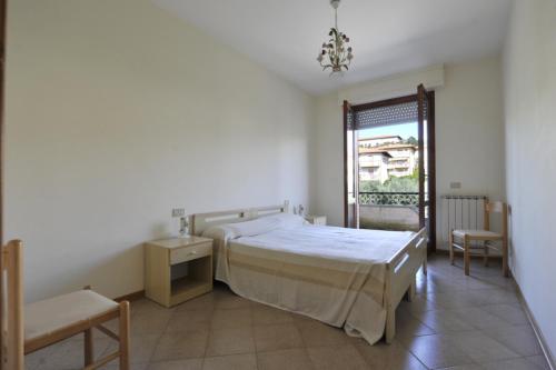 a white bedroom with a bed and a window at Tommaso 2 Sopra in Tuoro sul Trasimeno