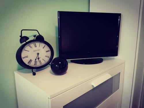 un reloj sentado en la parte superior de un tocador con televisión en Apartments Luza, en Lastovo