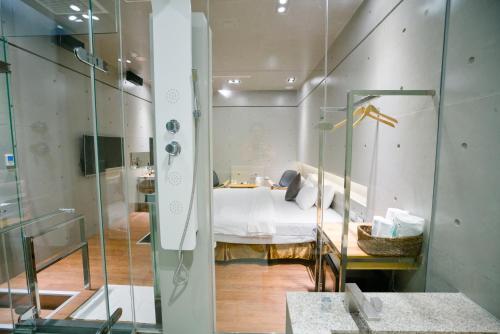 a bedroom with a bed and a glass wall at Hotel Shumei Chiayi in Zhongpu