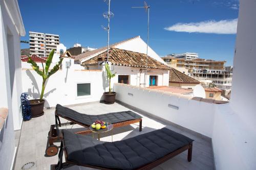 un balcón con 2 sillas y una mesa en un edificio en MONKÓ - BANANA & TROPYCAL APARTMENT o, en Torremolinos