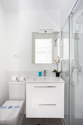 a white bathroom with a toilet and a sink at MONKÓ - BANANA & TROPYCAL APARTMENT o in Torremolinos