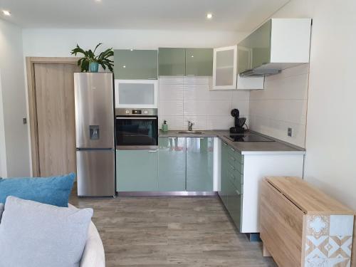 a kitchen with stainless steel appliances and white cabinets at PÉROLA D'ÓBIDOS t1 in Óbidos