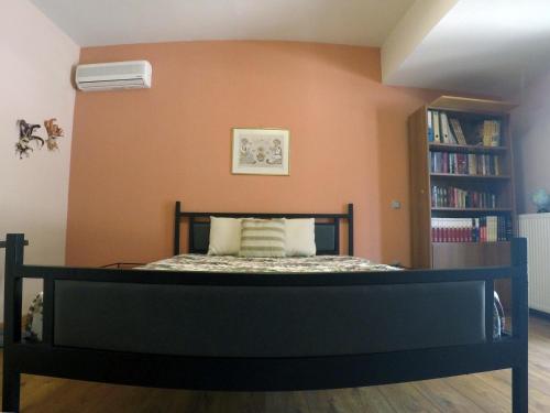 a bedroom with a bed with an orange wall at Luxury Villa with Private Pool in Keratea