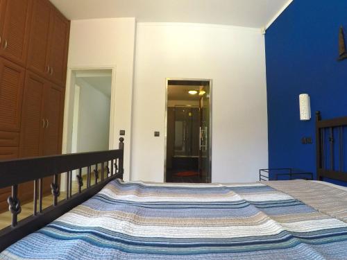 a bed in a bedroom with a blue wall at Luxury Villa with Private Pool in Keratea