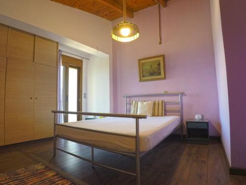 a bedroom with a bed and a pink wall at Luxury Villa with Private Pool in Keratea