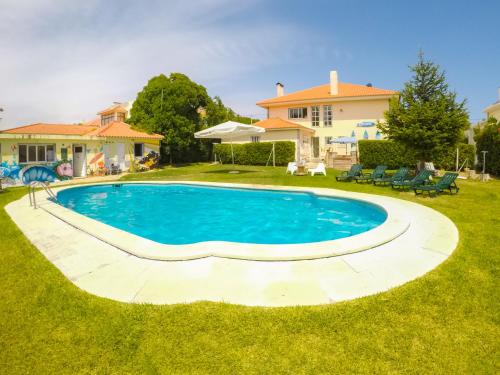 a swimming pool in the yard of a house at Carcavelos Surf Hostel & Surf Camp in Carcavelos