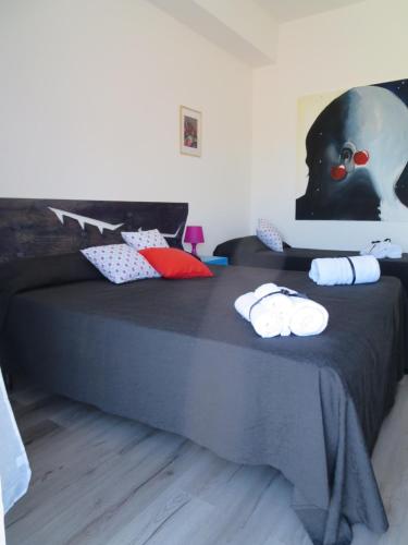 a bedroom with a black bed with towels on it at Idria B&B in Barcellona-Pozzo di Gotto