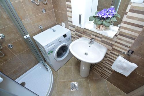 ein Badezimmer mit einem Waschbecken und einer Waschmaschine in der Unterkunft Apartment Petra in Tivat