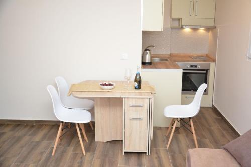 a small kitchen with a table and white chairs at Apartment Petra in Tivat