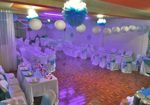 a room with white tables and chairs and purple lighting at VillaLoren in San Antonio del Tequendama
