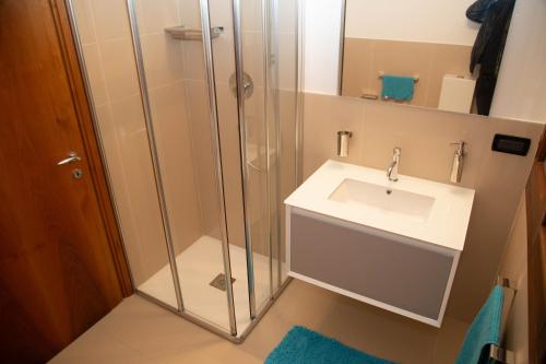 W łazience znajduje się umywalka i przeszklony prysznic. w obiekcie Azul - privacy tranquillità natura e mare w mieście Rosolina Mare