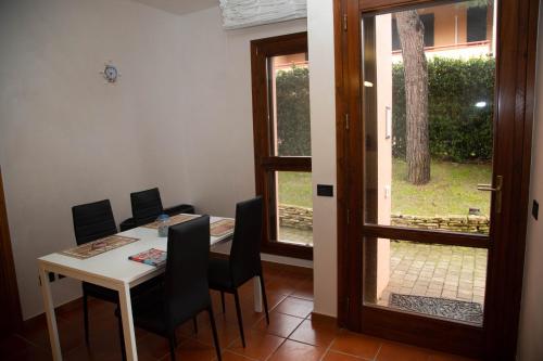 a dining room with a table and chairs and a window at Azul - privacy tranquillità natura e mare in Rosolina Mare