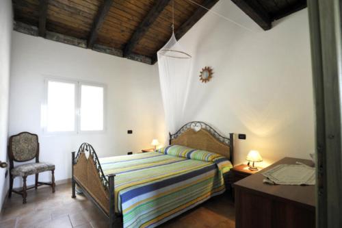 een slaapkamer met een bed, een tafel en een stoel bij Tutti Frutti in Pompeiana