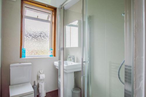 La salle de bains est pourvue de toilettes, d'un lavabo et d'une douche. dans l'établissement Montgomery Apartments - Stevensons, à Édimbourg