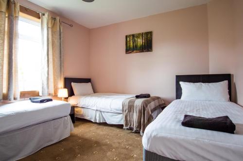 Cette chambre comprend 2 lits et une fenêtre. dans l'établissement Montgomery Apartments - Stevensons, à Édimbourg