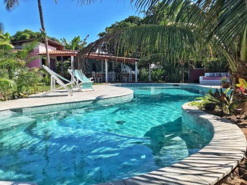 a swimming pool with a walkway around it at Pousada Ilha do Vento in São Miguel do Gostoso
